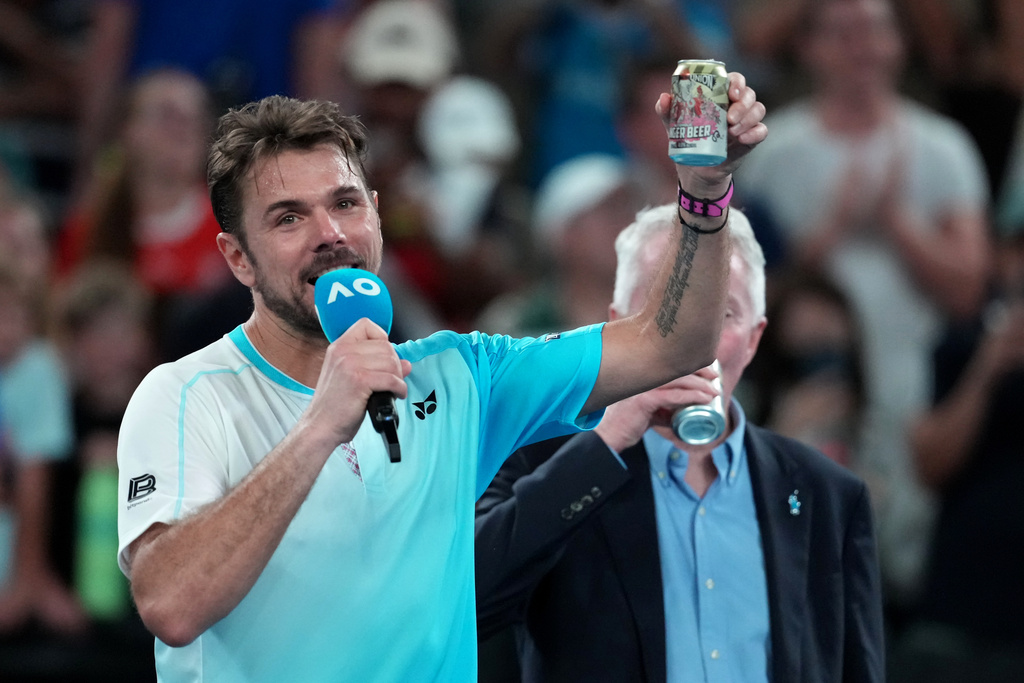 Stan Wawrinka of Switzerland holds up a beer following his third round loss to Taylor Fritz of the U.S. at the Australian Open tennis championship in Melbourne, Australia, Saturday, Jan. 24, 2026. (AP Photo/Asanka Brendon Ratnayake)