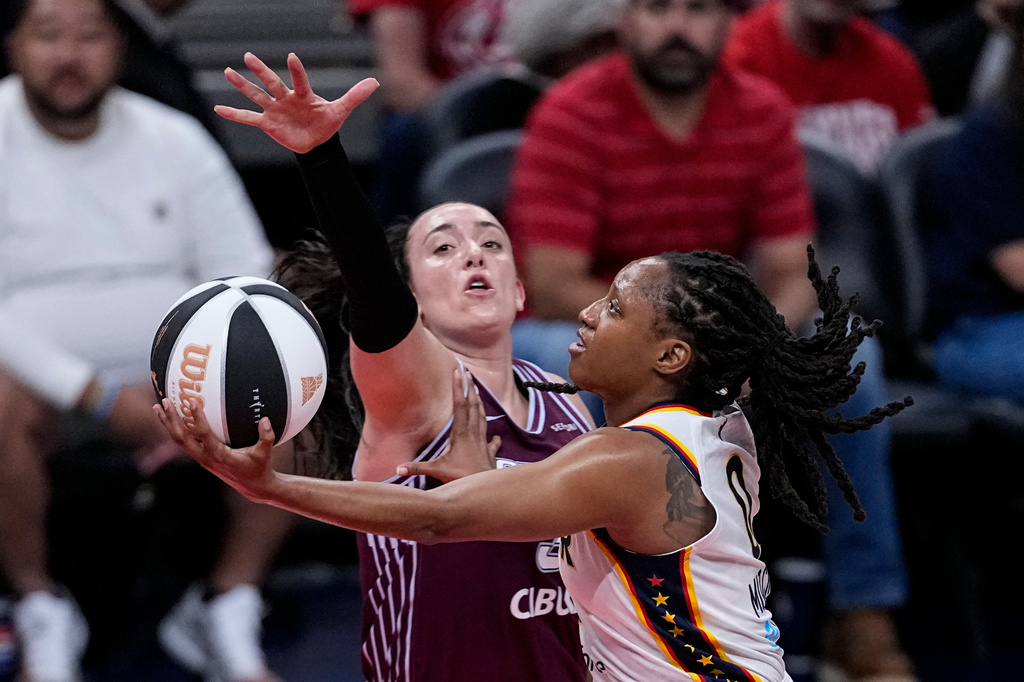 Indiana Fever guard Kelsey Mitchell, right, shoots around Toronto Tempo guard Marina Mabrey, center, in the first half of a WNBA Commissioner's Cup basketball game in Indianapolis, Tuesday, June 16, 2026. (AP Photo/Michael Conroy)
