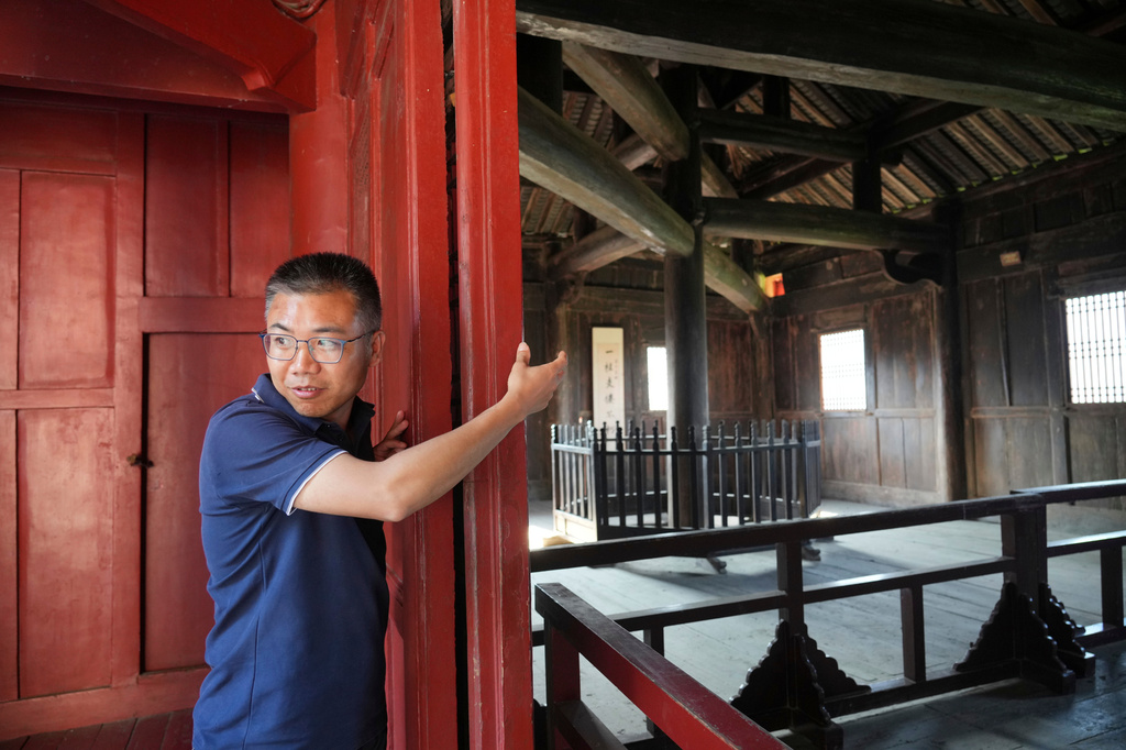 Shu Chenghai, director of social education at Wudang Museum points towards where twelve beams are mortised and interlocked at varying angles the Wuyun Tower in Wudang Mountains in central China's Hubei Province on Sept. 3, 2026. (AP Photo/Achmad Ibrahim)