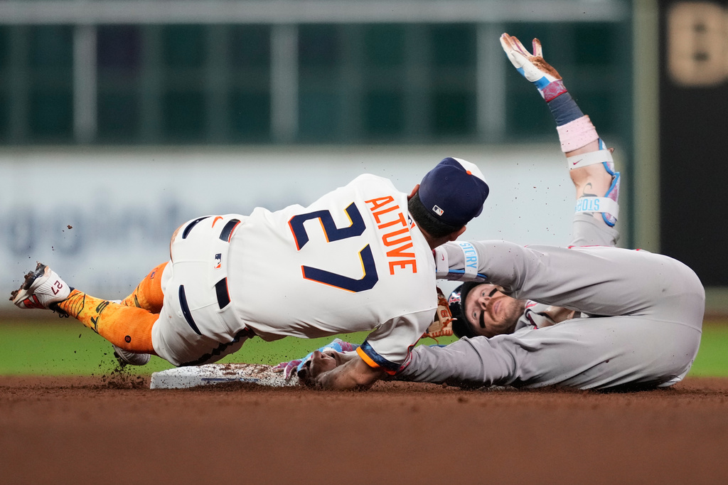 Boston Red Sox's Trevor Story, right, is safe at second on a double, ahead of a tag by Houston Astros second baseman Jose Altuve (27) during the seventh inning of a baseball game in Houston, Monday, March 30, 2026. (AP Photo/Ashley Landis)