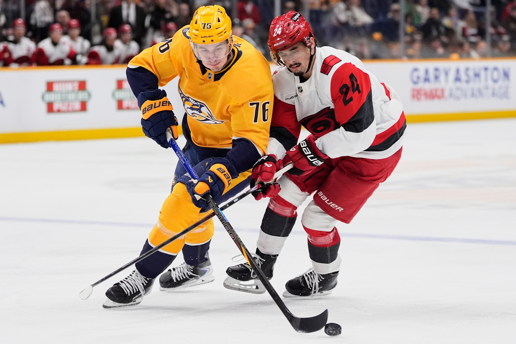 Nashville Predators defenseman Brady Skjei (76) moves the puck past Carolina Hurricanes center Seth Jarvis (24) during the first period of an NHL hockey game Wednesday, Dec. 17, 2025, in Nashville, Tenn. (AP Photo/George Walker IV)
