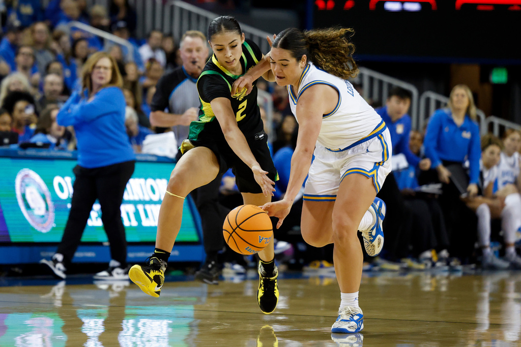 Oregon guard Katie Fiso (2) and UCLA guard Charlisse Leger-Walker, right, fight for possession of the ball during the first half of an NCAA college basketball game Sunday, Dec. 7, 2025, in Los Angeles. (AP Photo/Caroline Brehman)