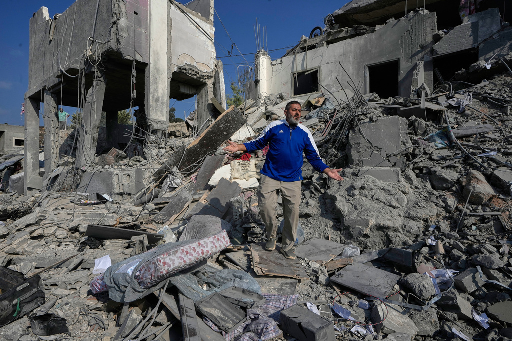 A man reacts on the rubble of a destroyed home that was hit by an Israeli airstrike in Ansar village, southern Lebanon, Saturday, Aug. 15, 2026. (AP Photo/Mohammed Zaatari)