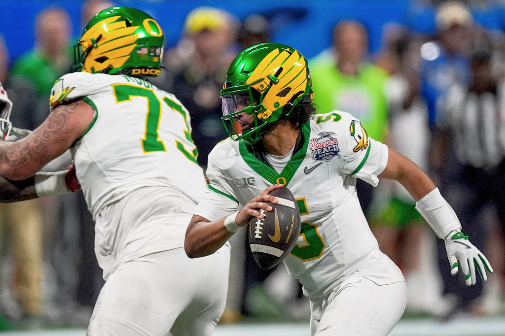 FILE - Oregon quarterback Dante Moore (5) works against Indiana during the second half of the Peach Bowl NCAA college football playoff semifinal, Jan. 9, 2026, in Atlanta. (AP Photo/Mike Stewart, File)