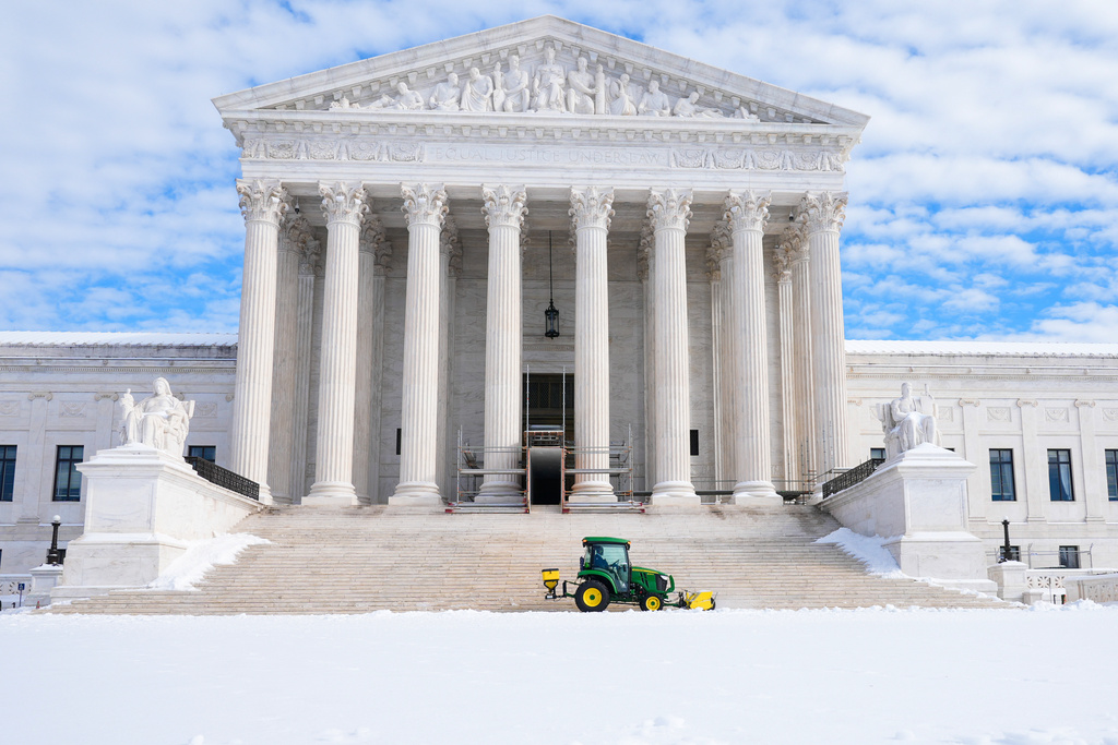 A worker clears snow at the U.S. Supreme Court after a snowstorm Monday, Jan. 26, 2026, in Washington. (AP Photo/Mariam Zuhaib)