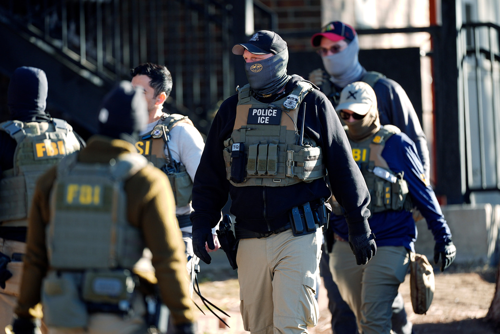 FILE - Law officials spread out through an apartment complex during a raid, Feb. 5, 2025, in east Denver. (AP Photo/David Zalubowski, File)