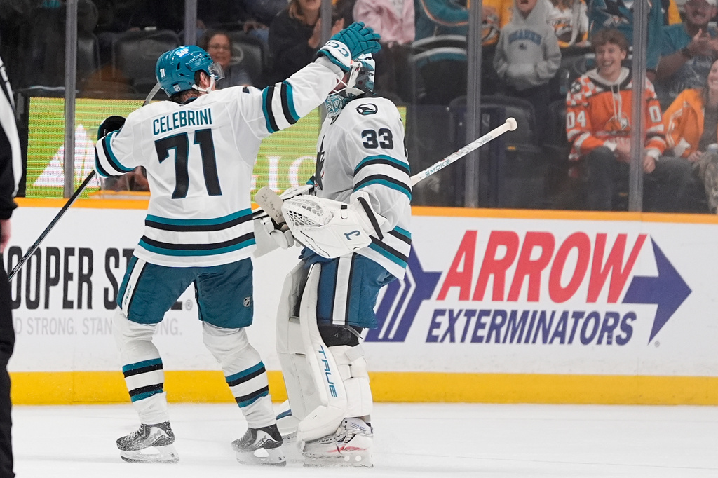 San Jose Sharks center Macklin Celebrini (71) congratulates goaltender Alex Nedeljkovic (33) after the team's shootout win in an NHL hockey game against the Nashville Predators, Thursday, Oct. 15, 2026, in Nashville, Tenn. (AP Photo/George Walker IV)