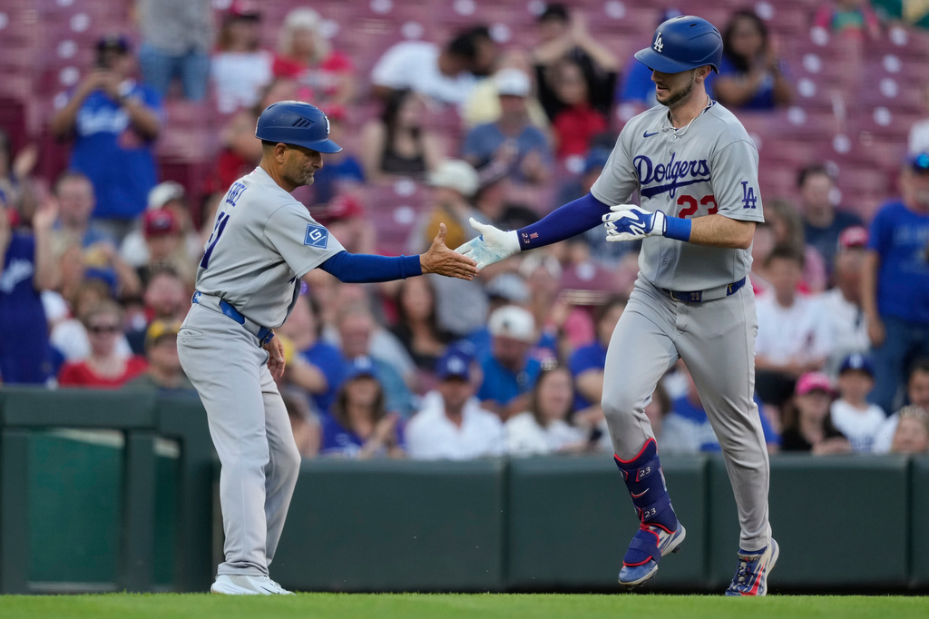Los Angeles Dodgers right fielder Kyle Tucker, (23) celebrates with third base coach Dino Ebel (91) as he rounds third base after hitting a solo home run during the second inning of a baseball game against the Cincinnati Reds, Monday, Sept. 14, 2026, in Cincinnati. (AP Photo/Carolyn Kaster)