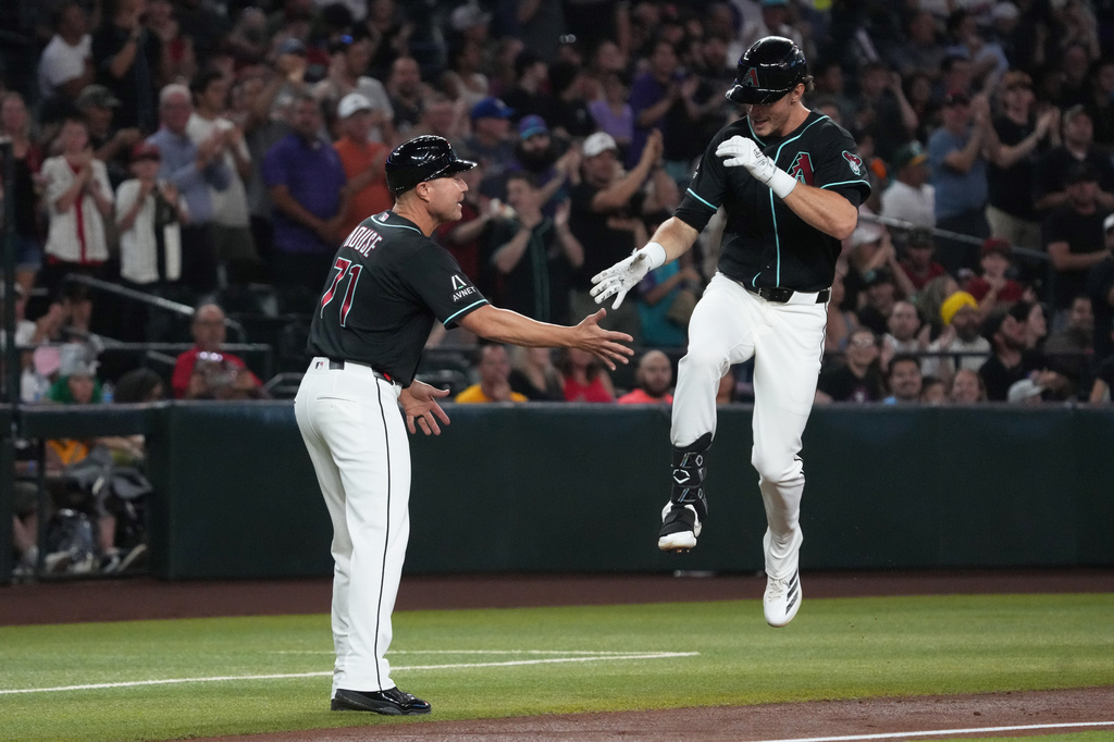 Arizona Diamondbacks' Max Kepler, right, celebrates with third base coach J.R. House (71) after hitting a three-run home run against the Athletics in the first inning of a baseball game, Tuesday, July 21, 2026, in Phoenix. (AP Photo/Rick Scuteri)