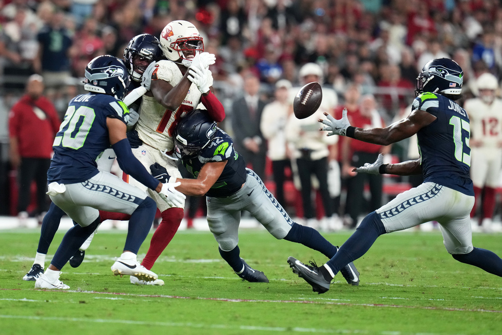 Seattle Seahawks linebacker Ernest Jones IV (13) intercepts a pass intended for Arizona Cardinals wide receiver Marvin Harrison Jr. (18) during the first half of an NFL football game Thursday, Sept. 25, 2025, in Glendale, Ariz. (AP Photo/Rick Scuteri)