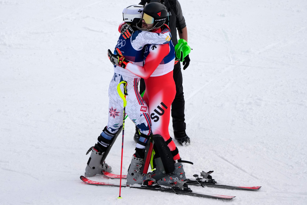 Norway's Henrik Kristoffersen, left, hugs Switzerland's Loic Meillard at the finish area, during an alpine ski, men's slalom race, at the 2026 Winter Olympics, in Bormio, Italy, Monday, Feb. 16, 2026. (AP Photo/John Locher)