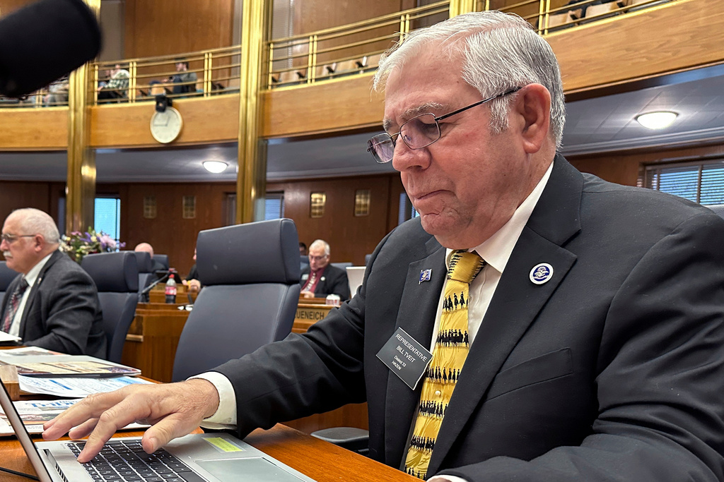 FILE - North Dakota Republican state Rep. Bill Tveit works at his desk, Jan. 22, 2025, in the House of Representatives at the state Capitol in Bismarck, N.D. (AP Photo/Jack Dura, File)