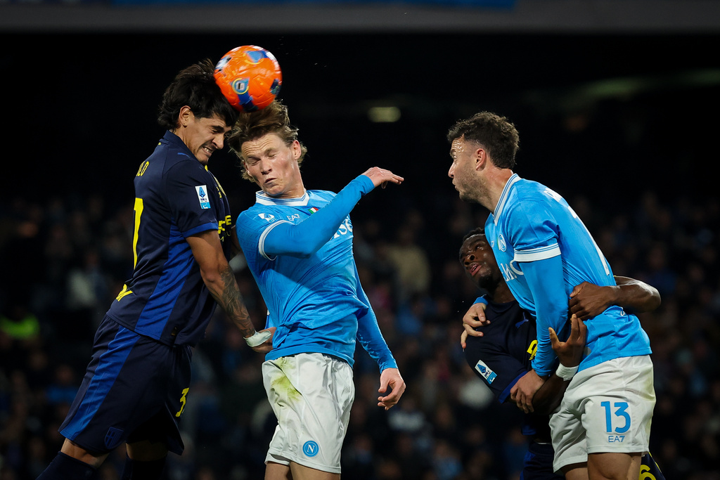 Napoli's Scott McTominay, center, and Parma's Mariano Troilo, left, in action during the Serie A soccer match between Napoli and Parma, in Naples, Italy, Wednesday, Jan. 14, 2026. (Alessandro Garofalo/LaPresse via AP)