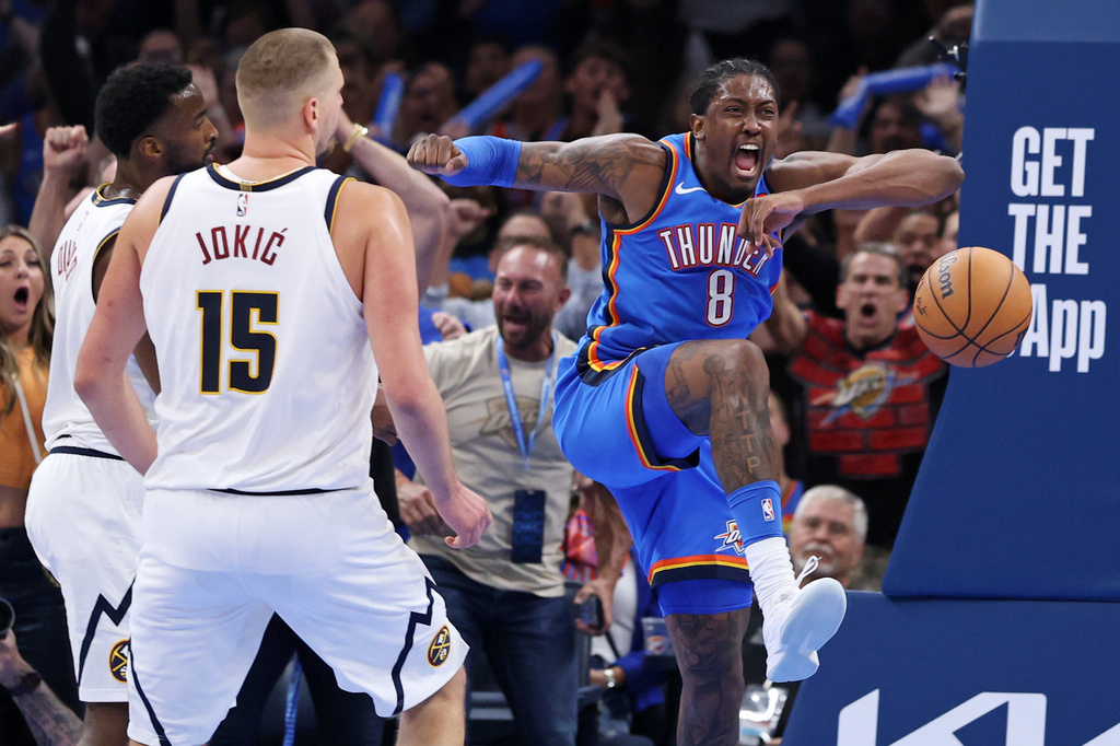 Oklahoma City Thunder guard Jalen Williams (8) reacts after dunking the ball near Denver Nuggets center Nikola Jokic (15) and forward Alpha Diallo, left, during the second half of an NBA basketball game Thursday, Oct. 22, 2026, in Oklahoma City. (AP Photo/Nate Billings)