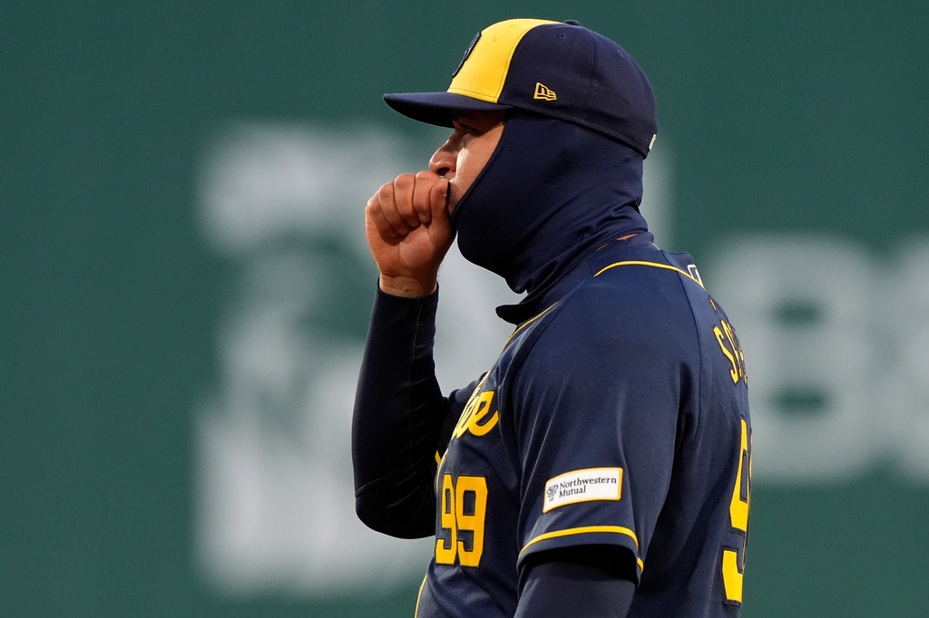 Milwaukee Brewers first baseman Gary Sánchez blows into his hand on a 43-degree F night during the third inning of a baseball game against the Boston Red Sox Tuesday, April 7, 2026, in Boston. (AP Photo/Robert F. Bukaty)