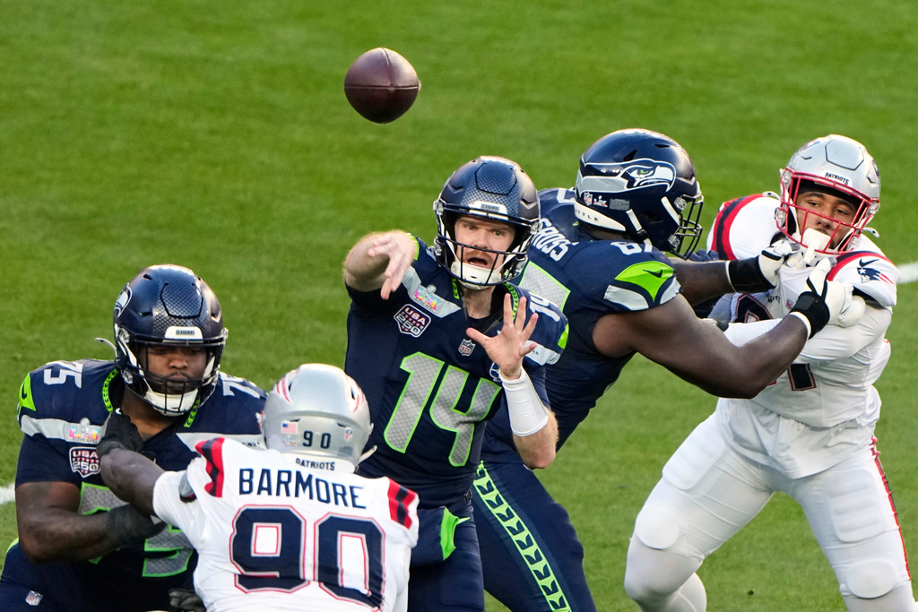 Seattle Seahawks quarterback Sam Darnold (14) throws a pass under pressure from New England Patriots defensive tackle Christian Barmore (90) during the first half of the NFL Super Bowl 60 football game, Sunday, Feb. 8, 2026, in Santa Clara, Calif. (AP Photo/Charlie Riedel)