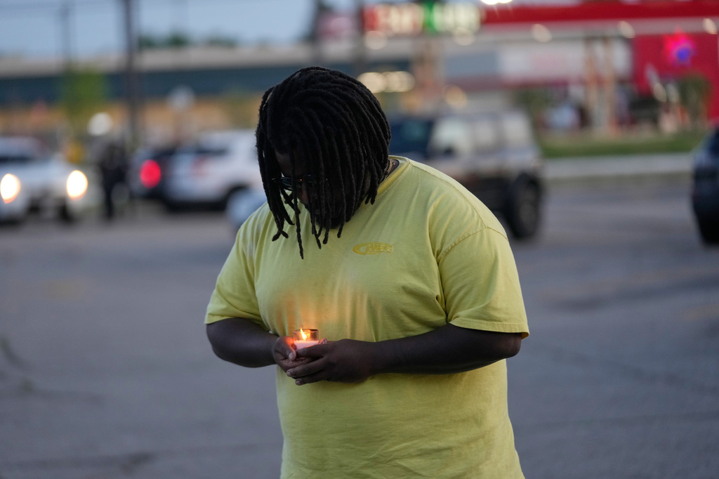 A man holds a candle during a prayer vigil for the victims of a mass shooting earlier in the day, Sunday, April 19, 2026, in Shreveport, La. (AP Photo/Gerald Herbert)