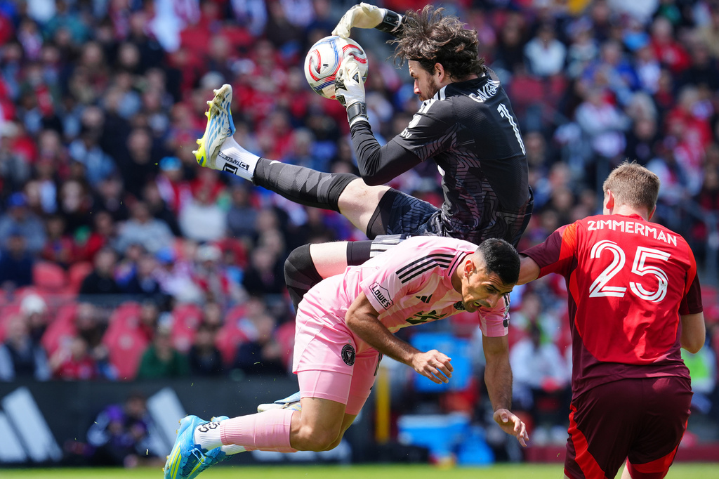 Toronto FC goalkeeper Luka Gavran (1) collides with Inter Miami CF forward German Berterame (19) as Toronto's Walker Zimmerman (25) looks on during first half MLS soccer in Toronto on Saturday, May 9, 2026. (Frank Gunn /The Canadian Press via AP)