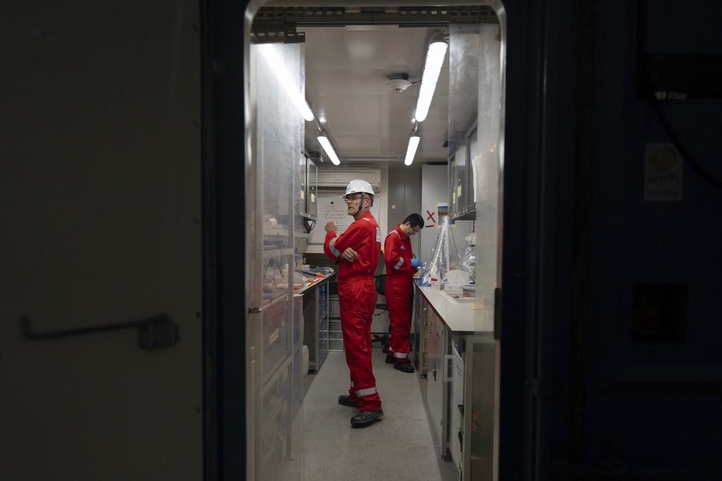 Expedition 501 researchers Xinxu Zhang, of Shenzhen University China, right, and Antonio Ferreira, an environmental geochemist with the British Geological Survey, work aboard the Liftboat Robert platform, in the North Atlantic, Sunday, July 20, 2025. (AP Photo/Carolyn Kaster)