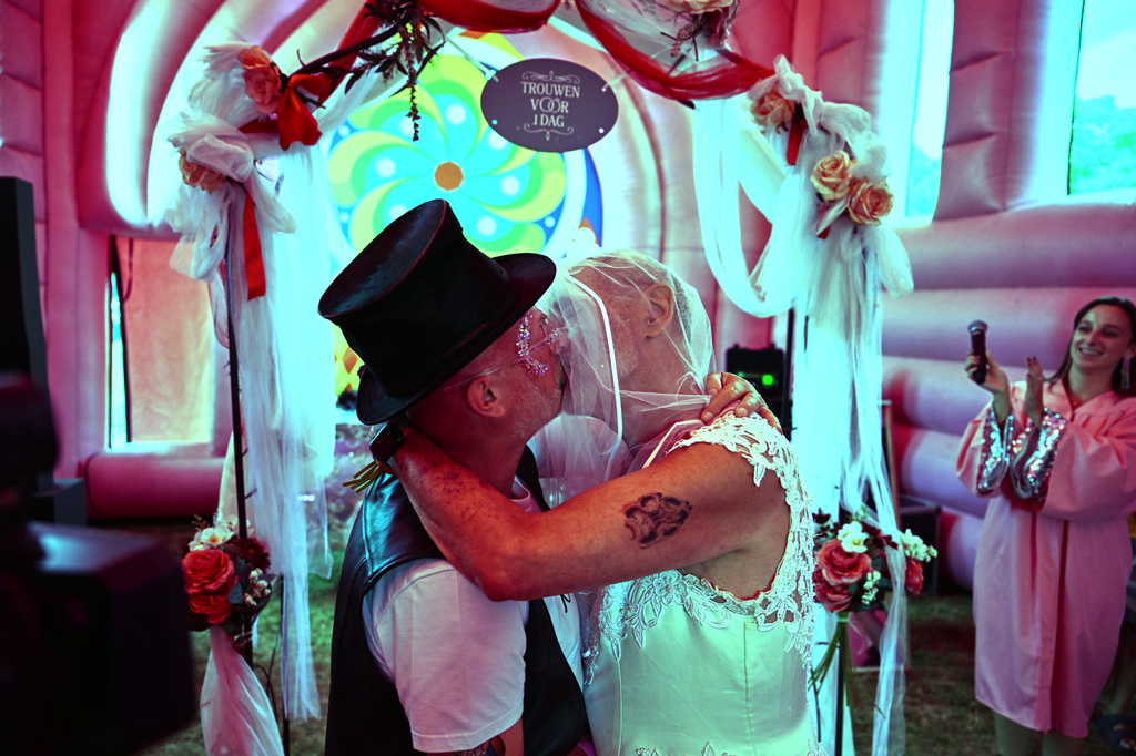 Jan Derksen-Wynn, right, and and John Wijfjes kiss after exchanging vows during a mass wedding ceremony in an inflatable chapel in Amsterdam, Netherlands, Thursday, Aug. 6, 2026, as part of Pride events celebrating 25 years since the Netherlands became the first country in the world to legalize same-sex marriage. (AP Photo/Mouneb Taim)