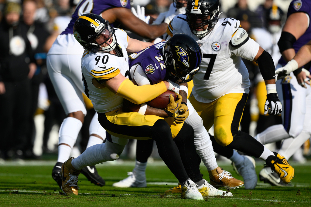 Pittsburgh Steelers linebacker T.J. Watt (90) tackles Baltimore Ravens running back Derrick Henry (22) during the first half of an NFL football game, Sunday, Dec. 7, 2025, in Baltimore. (AP Photo/Nick Wass)