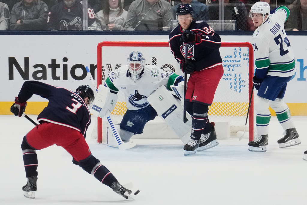Columbus Blue Jackets center Charlie Coyle (3) skates in on Vancouver Canucks goaltender Kevin Lankinen (32) in the first period of an NHL hockey game Thursday, Jan. 15, 2026, in Columbus, Ohio. (AP Photo/Sue Ogrocki)