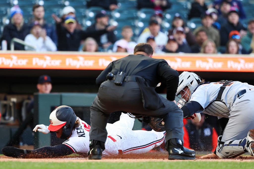 Minnesota Twins' Luke Keaschall, left, slides safely into home plate while Detroit Tigers catcher Dillon Dingler, right, attempts to tag him out during the first inning of a baseball game Wednesday, April 8, 2026, in Minneapolis. (AP Photo/Ellen Schmidt)