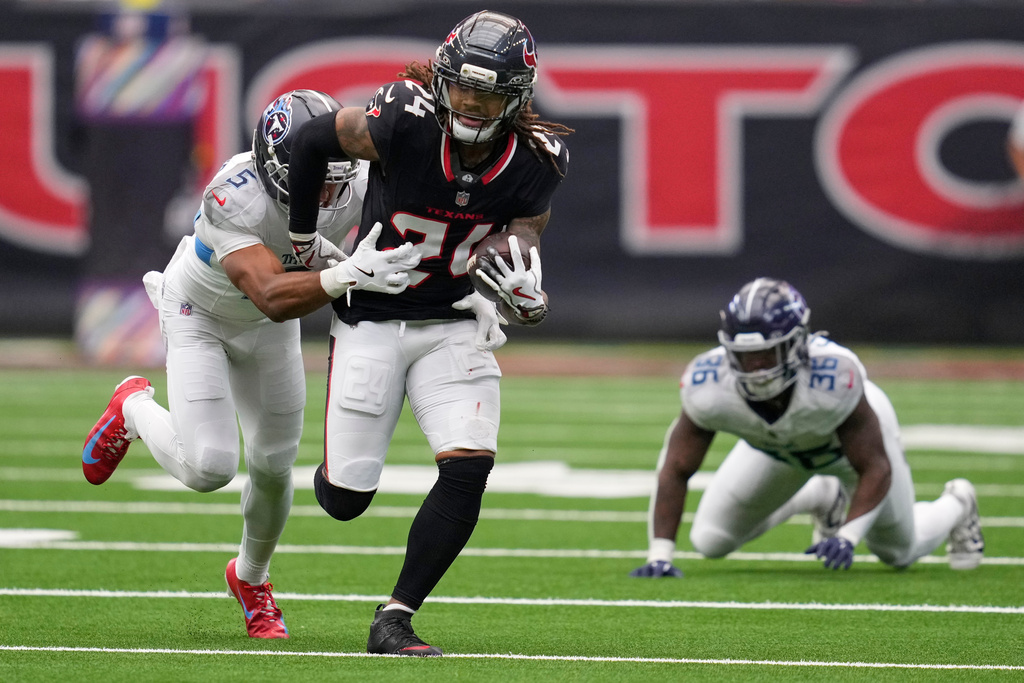 Houston Texans cornerback Derek Stingley Jr. (24) returns an interception as he is tackled by Tennessee Titans wide receiver Elic Ayomanor (5) during the second half of an NFL football game Sunday, Sept. 28, 2025, in Houston. (AP Photo/Ashley Landis)