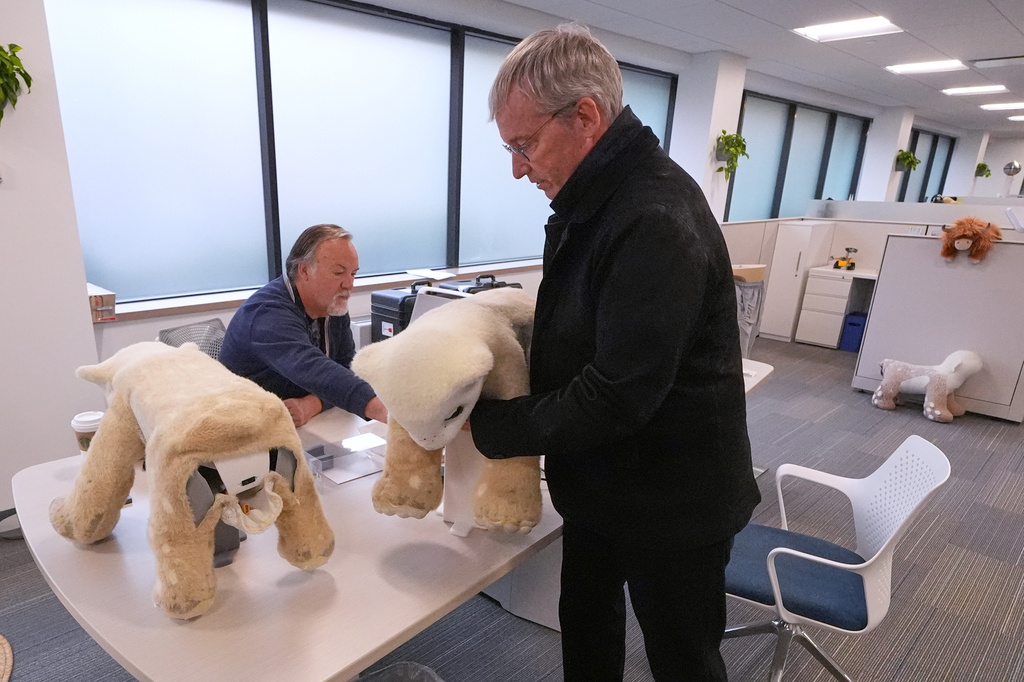 Colin Angle, co-founder and former CEO of Roomba vacuum maker, lifts Familiar, a prototype AI pet robot, at the Massachusetts-based startup Familiar Machines & Magic, Wednesday, April 29, 2026, in Woburn, Mass. (AP Photo/Charles Krupa)