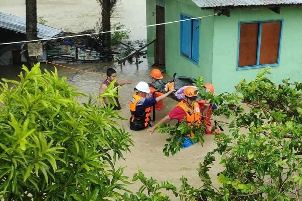 In this handout provided by the Philippine Coast Guard, rescuers evacuate a resident to safer grounds as floods rise due to Tropical Storm Bualoi in Odiongan, Romblon province, Philippines on Friday Sept. 26, 2025. (Philippine Coast Guard via AP)
