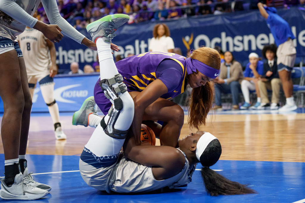 LSU guard Zakiyah Johnson, top, and New Orleans forward Sephora Kayolo , bottom, battle for the ball during the first half of an NCAA college basketball game on Sunday, Dec. 7, 2025, in New Orleans. (AP Photo/Matthew Hinton)