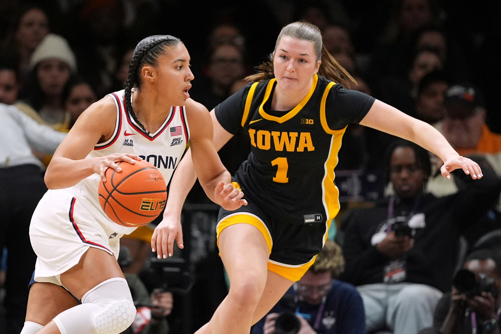 UConn's Azzi Fudd, left, drives past Iowa's Taylor Stremlow during the first half of an NCAA college basketball game Saturday, Dec. 20, 2025, in New York. (AP Photo/Frank Franklin II)