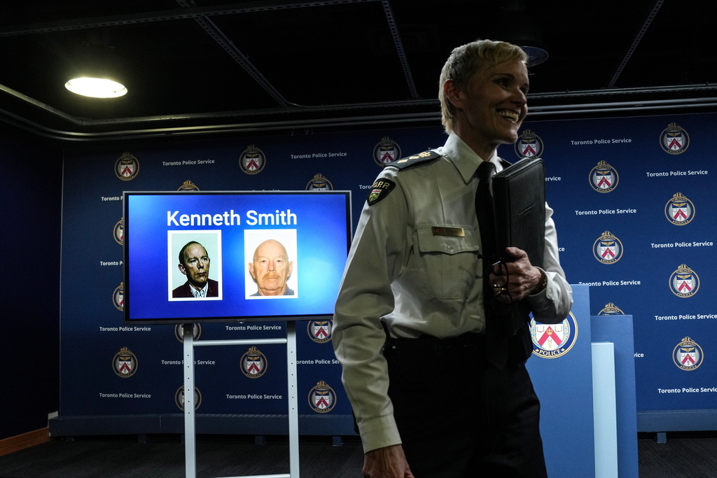 Chief Superintendent Karen Gonneau of the Ontario Provincial Police stands in front of a screen displaying images of Kenneth Smith as police provide a development in three historical homicide investigations, Thursday, Dec. 11, 2025, during a news conference at police headquarters in Toronto. (Chris Young/The Canadian Press via AP)