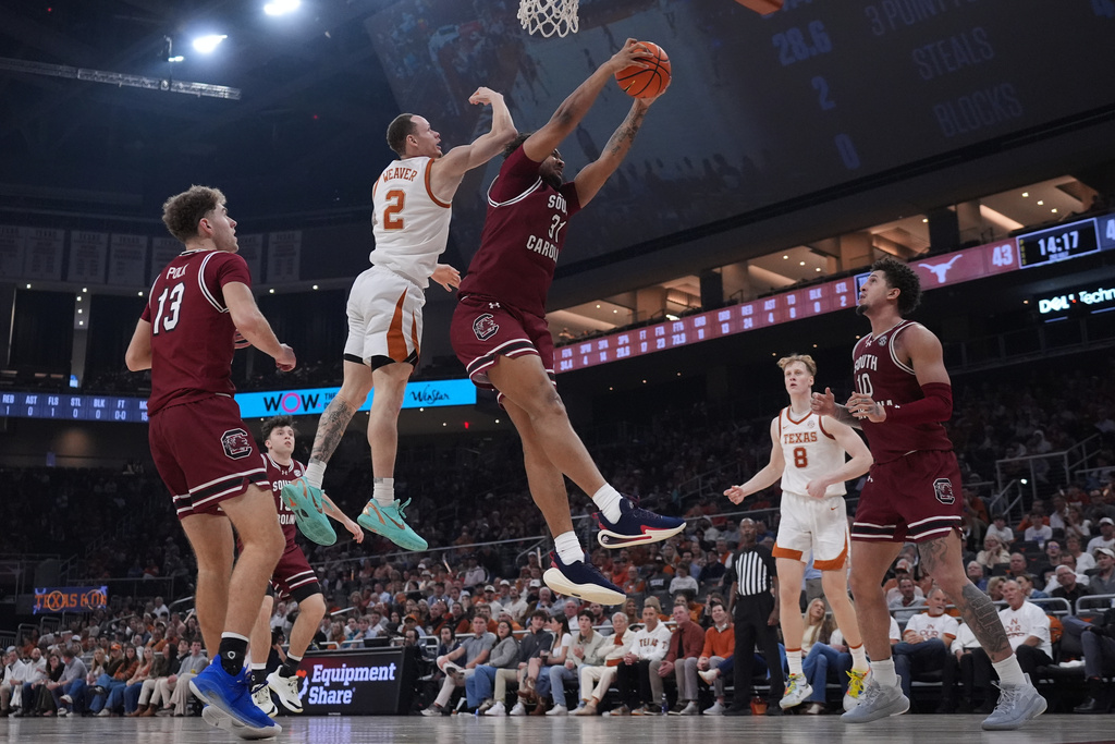 South Carolina forward Elijah Strong (31) grabs a rebound in front of Texas guard Chendall Weaver (2) during the second half of an NCAA college basketball game in Austin, Texas, Feb. 3, 2026. (AP Photo/Eric Gay)