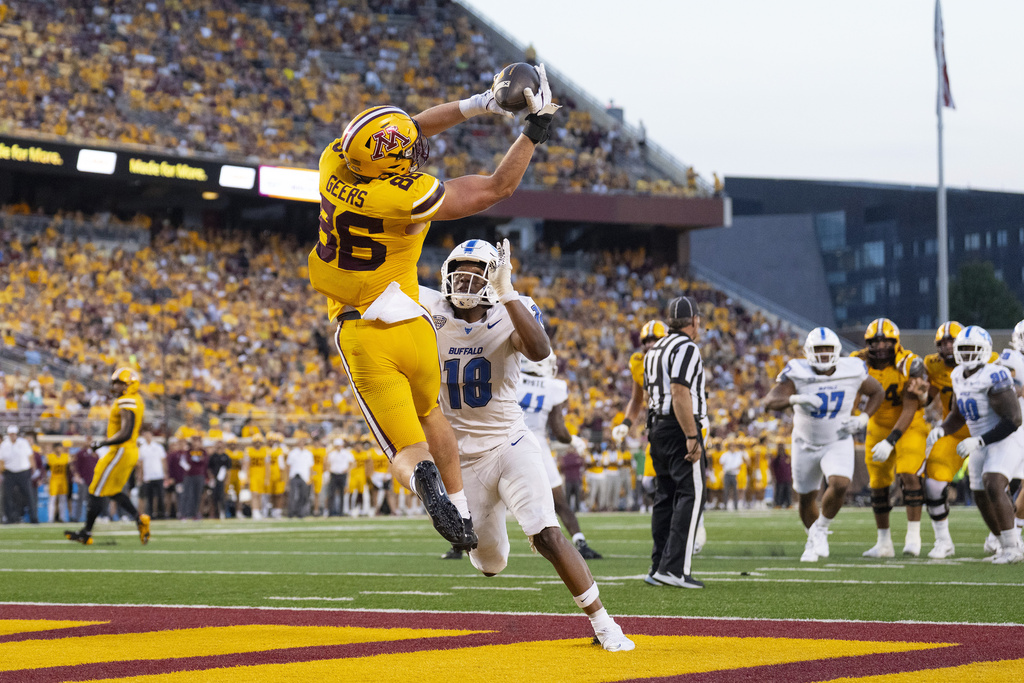 Minnesota tight end Jameson Geers (86) catches his team's first touchdown of the season while defended by Buffalo linebacker Dion Crawford (18) in the second quarter of an NCAA college football game in Minneapolis, Thursday, Aug. 28, 2025. (Alex Kormann/Star Tribune via AP)