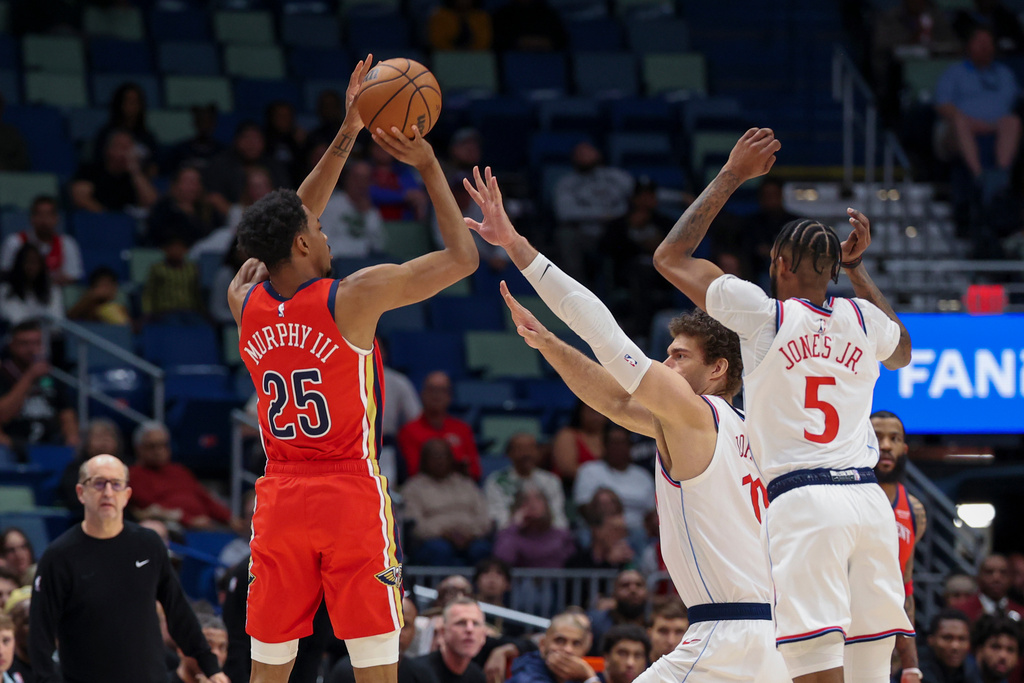 New Orleans Pelicans forward Trey Murphy III (25) shoots a three-pointer over Los Angeles Clippers center Brook Lopez (11) and forward Derrick Jones Jr. (5) in the first half of an NBA basketball game in New Orleans, Thursday, March 19, 2026. (AP Photo/Peter Forest)