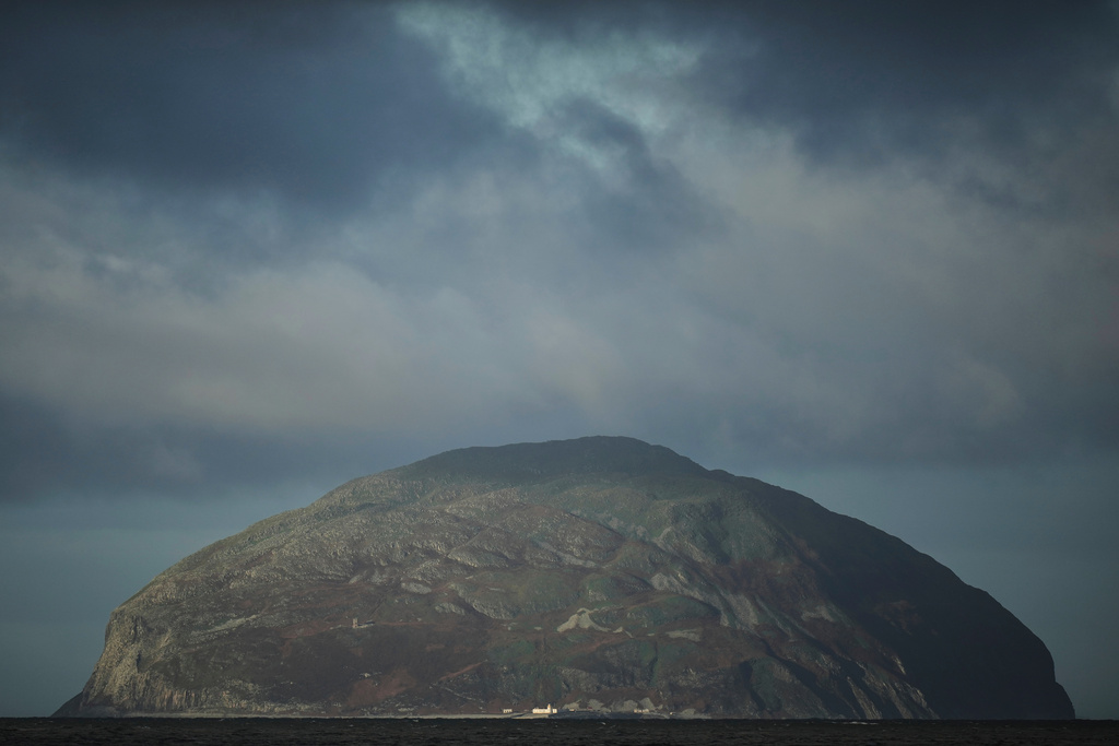 The island of Ailsa Craig, where the two types of granite, Common Green and Blue Hone, that are used to make curling stones is quarried from, is seen from the beach at Girvan, Scotland, Thursday, Nov. 13, 2025. (AP Photo/Alastair Grant)