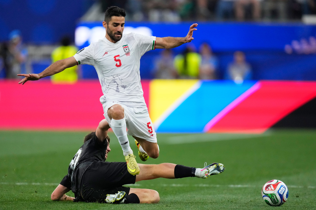 Iran's Milad Mohammadi (5) jumps over New Zealand's Callum McCowatt (20) during the World Cup Group G soccer match between Iran and New Zealand in Inglewood, Calif., near Los Angeles, Monday, June 15, 2026. (AP Photo/Mark J. Terrill)