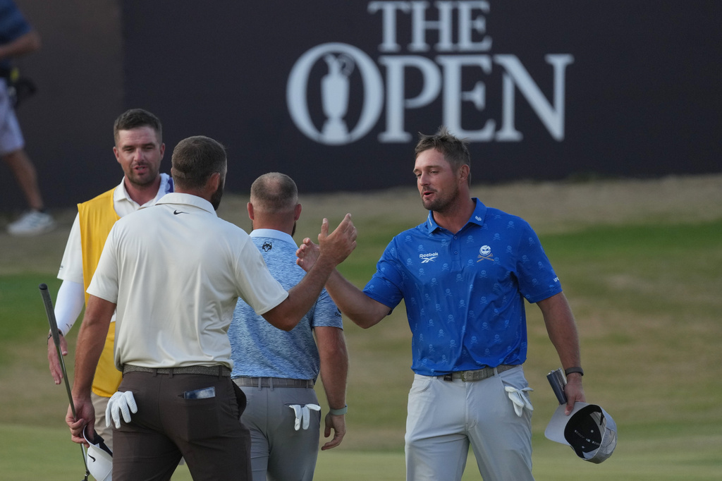 Bryson DeChambeau of the United States, right shakes hands with Scottie Scheffler of the United States after they completed their second rounds on the 18th green during the second day of the British Open Golf championships at Royal Birkdale golf club, in Southport, England, Friday, July 17, 2026. (AP Photo/Jon Super)