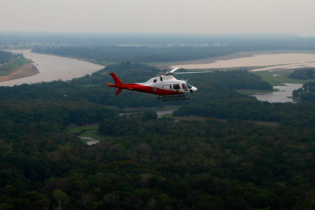 A helicopter from Brazil's environmental agency flies over an area of the Amazon rainforest during a wildfire-fighting operation in Autazes, Amazonas state, Brazil, Thursday, Oct. 15, 2026. (AP Photo/Edmar Barros)