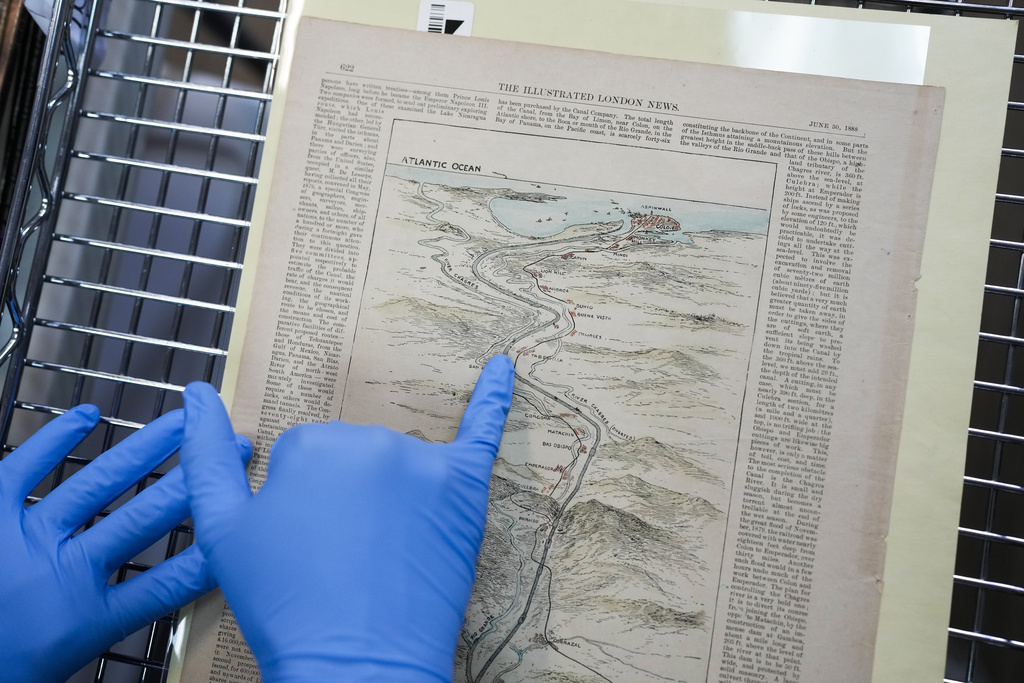 Researcher Esteban Zabala presents an 1888 map of the world's first transcontinental railway, a document that also included early canal route proposals, at the Panama Canal Museum in Panama City, Wednesday, Aug. 13, 2025. (AP Photo/Matias Delacroix)