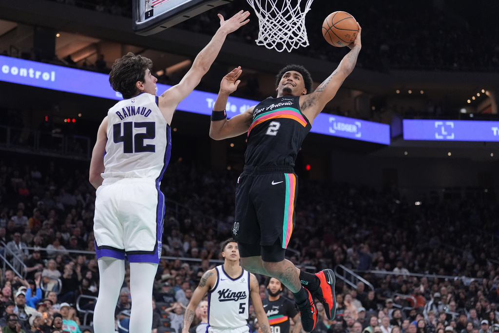 San Antonio Spurs guard Dylan Harper (2) shoots the ball against Sacramento Kings center Maxime Raynaud (42) during the second half of an NBA basketball game in Austin, Texas, Saturday, Feb. 21, 2026. (AP Photo/Eric Gay)