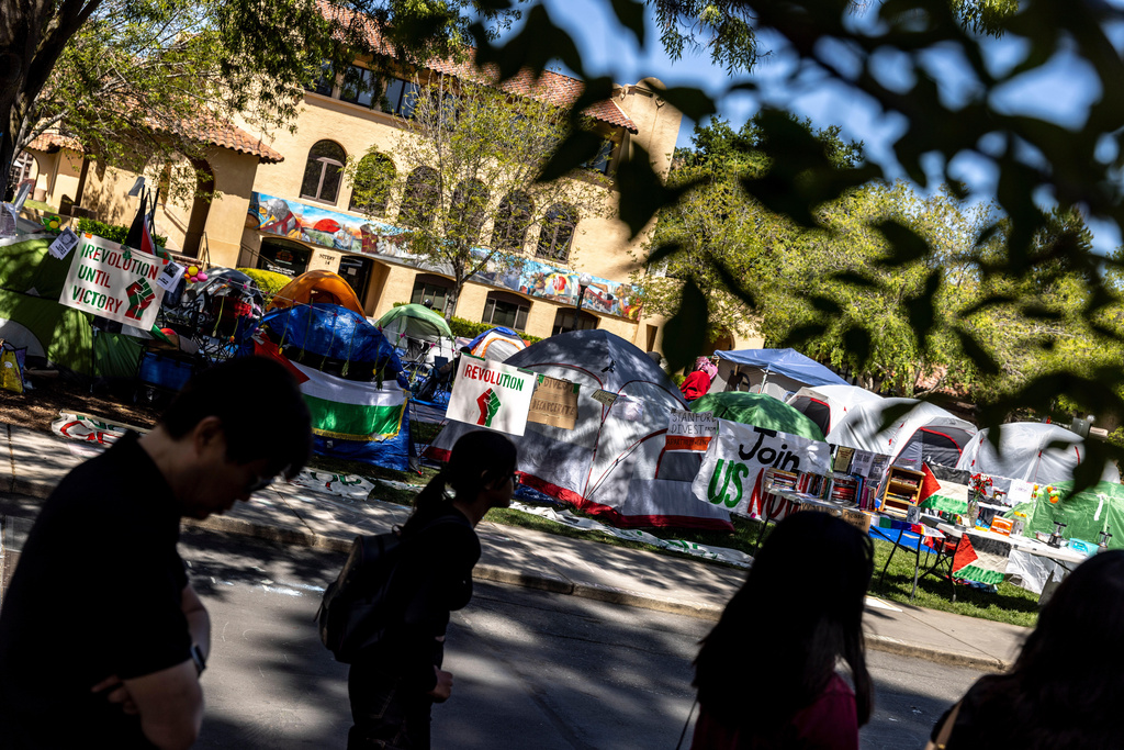 FILE - A group of prospective students walk by a tent encampment in White Plaza at Stanford University in Stanford, Calif., in support of Palestinians, April 30, 2024. (Stephen Lam/San Francisco Chronicle via AP, File)