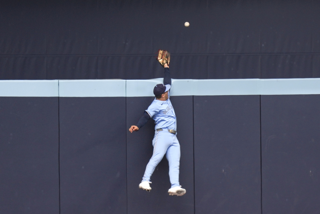 Toronto Blue Jays outfielder Daulton Varsho leaps to try to catch a solo home run hit by Baltimore Orioles' Coby Mayo during second-inning baseball game action in Toronto, Sunday, Sept. 14, 2025. (Chris Young/The Canadian Press via AP)