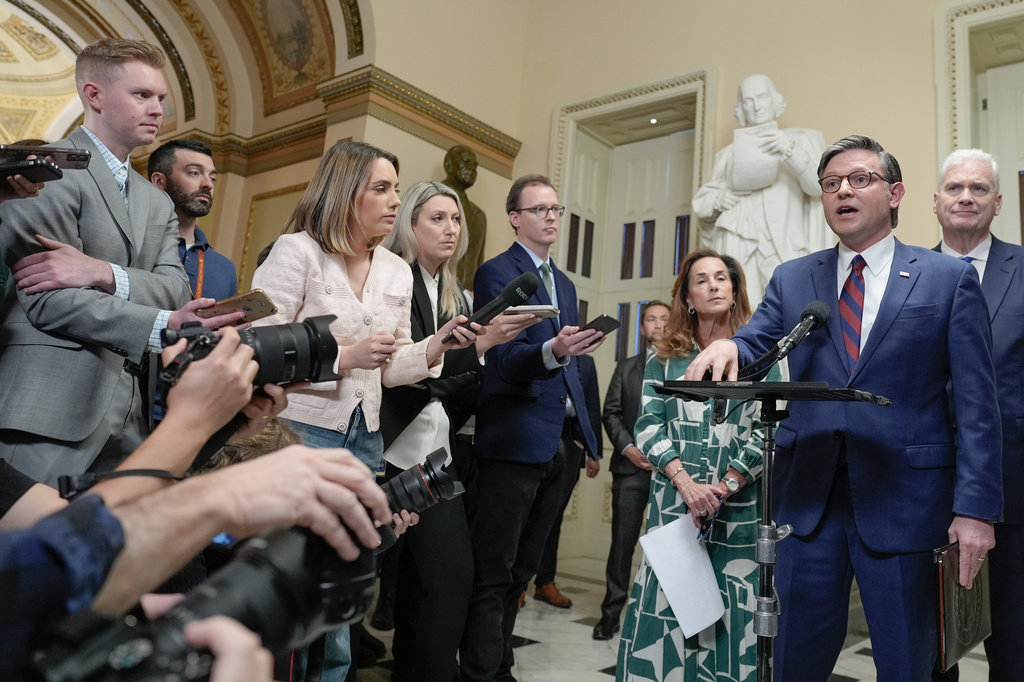 Speaker of the House Mike Johnson, R-La., speaks while House Majority Whip Tom Emmer R-Minn., right, and House Republican Conference Chair Lisa McClain, R-Mich., left, listen during a news conference on Capitol Hill, Friday, March 27, 2026, in Washington. (AP Photo/Mariam Zuhaib)