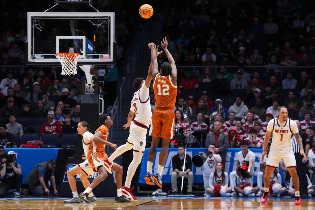 Texas guard Tramon Mark (12) scores a 3-point basket during the first half in a First Four college basketball game in the NCAA Tournament against North Carolina State, Tuesday, March 17, 2026, in Dayton, Ohio. (AP Photo/Kareem Elgazzar)