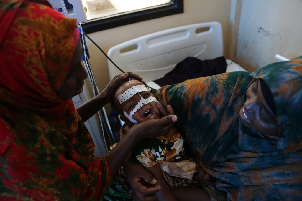 A mother sits with her malnourished baby at Banadir Hospital in Mogadishu, Somalia, Tuesday, Nov. 11, 2025. (AP Photo/Farah Abdi Warsameh)