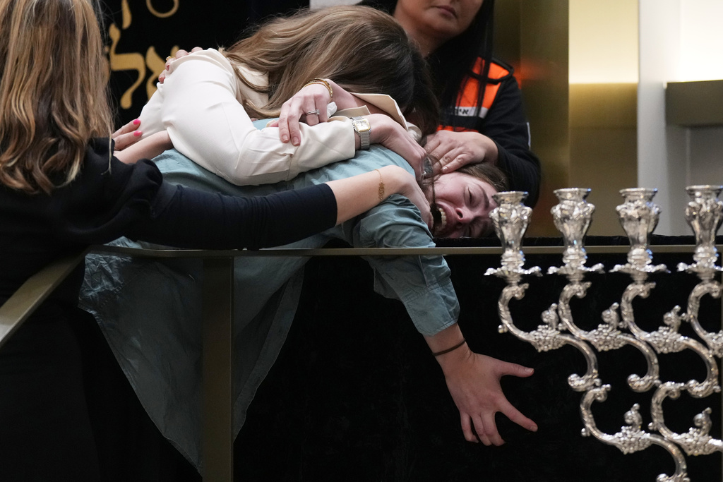 Family react at the coffin of Rabbi Eli Schlanger, a victim in the Bondi Beach mass shooting, during his funeral at a synagogue in Bondi on Wednesday, Dec. 17, 2025, in Sydney, Australia. (AP Photo/Mark Baker, Pool)