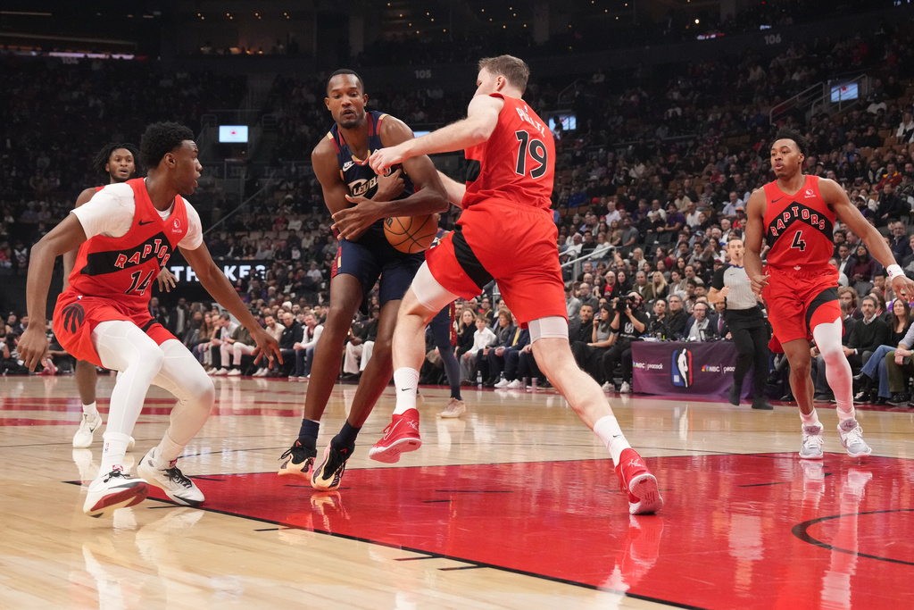 Cleveland Cavaliers center Evan Mobley (4) tries to take the ball past Toronto Raptors center Jakob Poeltl (19) during the first half of an NBA basketball game in Toronto on Monday Nov. 24, 2025. (Chris Young/The Canadian Press via AP)