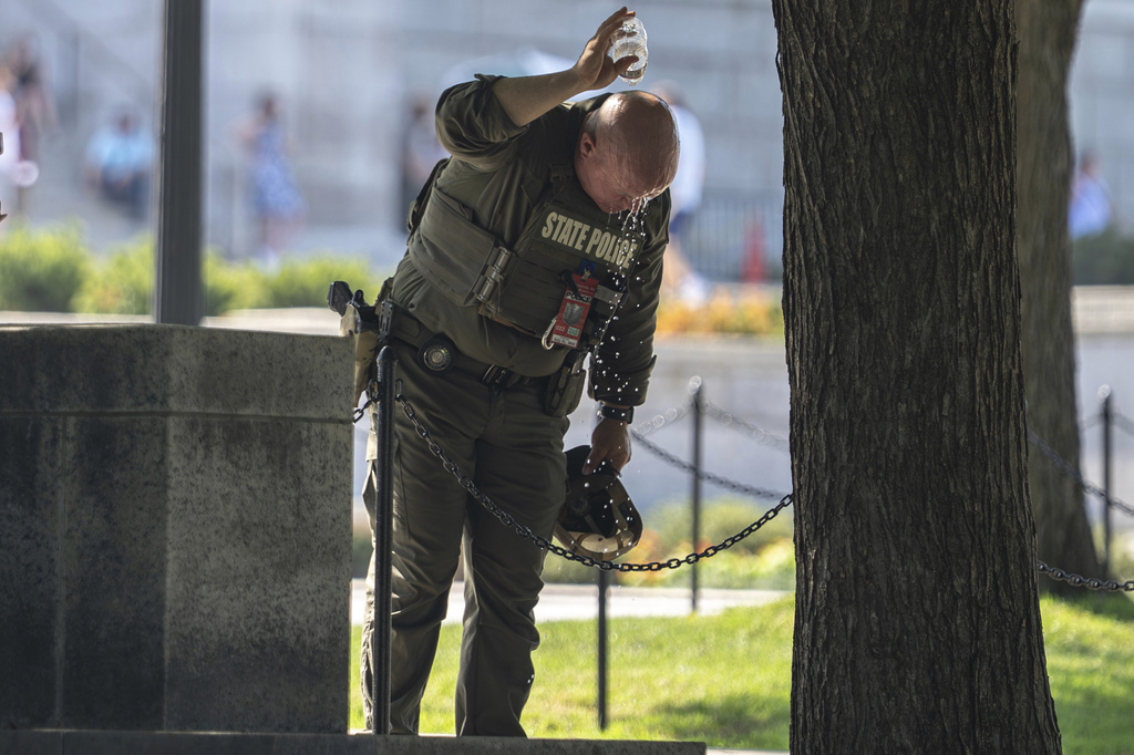 A member of the Texas State Troopers pours cold water over his head during an extreme head advisory near the Lincoln Memorial, while providing extra security ahead of the America 250 July 4th celebration, Thursday, July 2, 2026, in Washington. (AP Photo/Nathan Howard)
